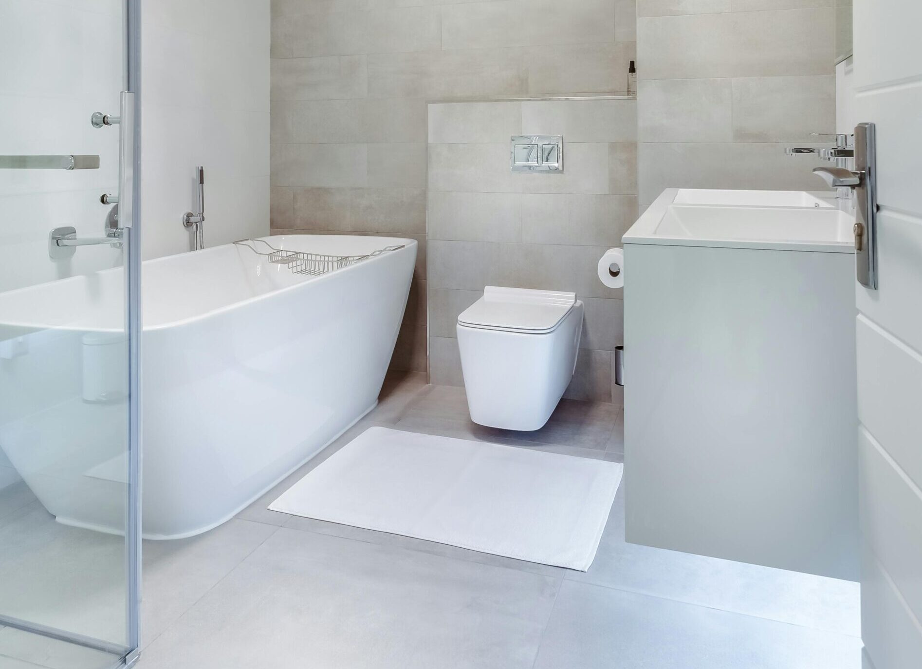 Elegant minimalistic bathroom featuring bathtub and sleek fixtures.