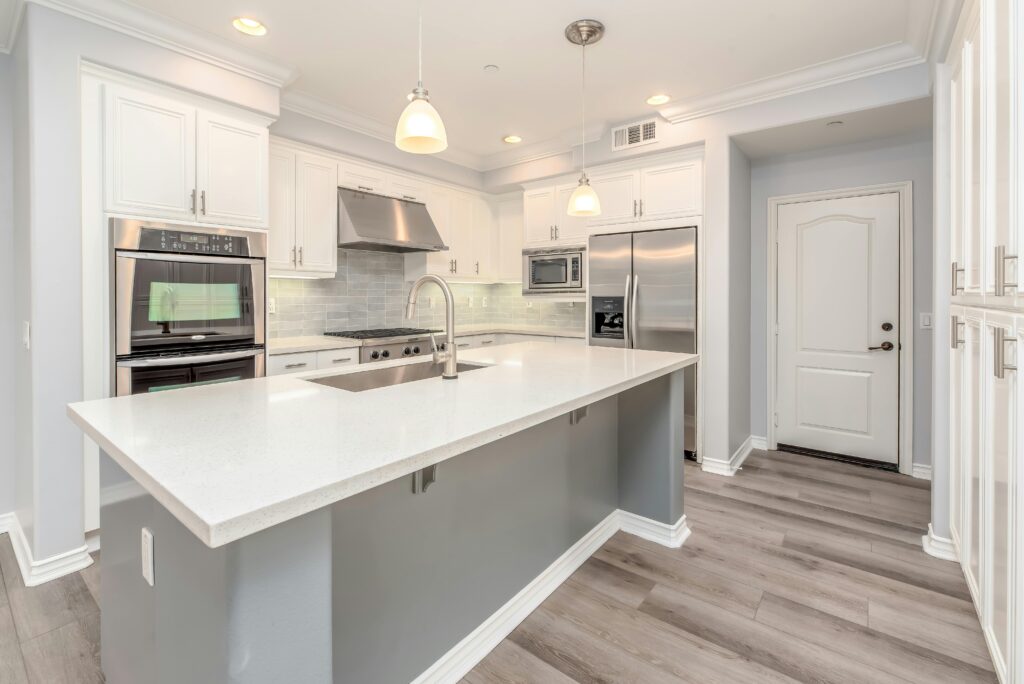 Modern kitchen interior featuring sleek white cabinetry and stainless steel appliances.